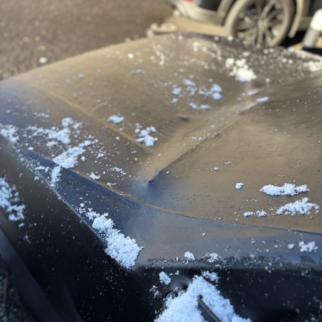 車カバー雪をはらっているところ